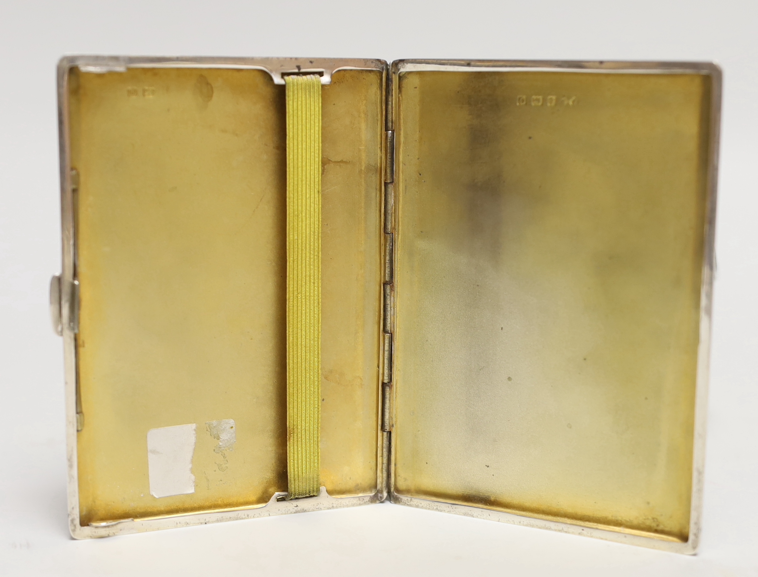 A George V engine turned silver cigarette case, 11.3cm a white metal sauceboat and a Wai Kee sterling pin dish.